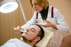 Terapista che applica una maschera di protezione al giovane immagini stock Terapista che applica una maschera di protezione al giovane immagini stock