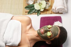 Termas Clay Mask Mulher com máscara facial da argila e pepinos no olho fotos de stock Termas Clay Mask Mulher com máscara facial da argila e pepinos no olho fotos de stock