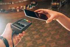 Terminale e smartphone durante il pagamento da NFC fotografia stock Terminale e smartphone durante il pagamento da NFC fotografia stock