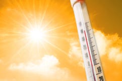 Termometer mot bakgrunden av ett varmt glöd för orange guling av moln och solen, begrepp av varmt väder arkivfoto Termometer mot bakgrunden av ett varmt glöd för orange guling av moln och solen, begrepp av varmt väder arkivfoto