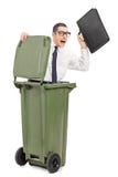 Terrified businessman hiding in a trash can stock photography Terrified businessman hiding in a trash can stock photography