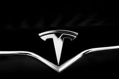 Tesla Emblem on Black Car. Close-Up Silver Logo