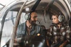 Tevreden mens die met jong geitje in helikopter communiceren royalty-vrije stock foto Tevreden mens die met jong geitje in helikopter communiceren royalty-vrije stock foto