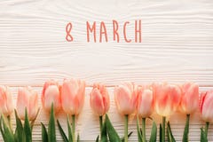 Textotez 8 mars sur les tulipes roses sur le fond en bois rustique blanc G Photos stock Textotez 8 mars sur les tulipes roses sur le fond en bois rustique blanc G Photos stock