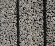 Textura de uma parede de pedras cinzentas pequenas, pequenas com duas ondulações no meio fotos de stock Textura de uma parede de pedras cinzentas pequenas, pequenas com duas ondulações no meio fotos de stock