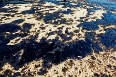 Texture of crude oil spill on sand beach from oil spill accident, Agios Kosmas bay, Athens, Greece, September 14 2017. stock photo Texture of crude oil spill on sand beach from oil spill accident, Agios Kosmas bay, Athens, Greece, September 14 2017. stock photo