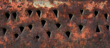 The texture of a rusty metal surface with triangular holes Stock Photos The texture of a rusty metal surface with triangular holes Stock Photos