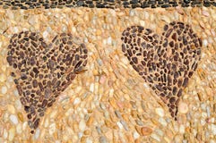 The texture of the stone wall, the road from small round and oval stones with abstracted lines of patterns of two hearts sandy royalty free stock images The texture of the stone wall, the road from small round and oval stones with abstracted lines of patterns of two hearts sandy royalty free stock images