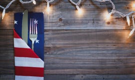 4th of July Celebration BBQ Dinner Table Place Setting with lights on rustic wood boards background with room or space for copy, t