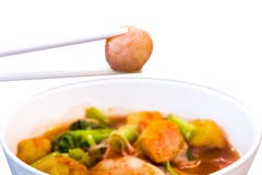 Thai food.Hold chopsticks to meat ball.Pink seafood flat noodles.Spicy lemongrass flavored soup with pork, chicken.Clipping path royalty free stock photo Thai food.Hold chopsticks to meat ball.Pink seafood flat noodles.Spicy lemongrass flavored soup with pork, chicken.Clipping path royalty free stock photo