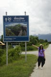 Thai women traveler posing for take photo with distance sign guide pole Stock Photography Thai women traveler posing for take photo with distance sign guide pole Stock Photography