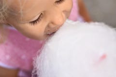 The Girl In The Pink Dress Eats White Cotton Candy, Top View Royalty Free Stock Image The Girl In The Pink Dress Eats White Cotton Candy, Top View Royalty Free Stock Image