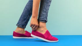 The Girl Straightens Right Sneakers On A Blue Floor. Royalty Free Stock Photo The Girl Straightens Right Sneakers On A Blue Floor. Royalty Free Stock Photo