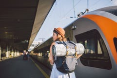 Theme transportation and travel. young caucasian woman standing at train station platform near train backs train background with stock photo Theme transportation and travel. young caucasian woman standing at train station platform near train backs train background with stock photo