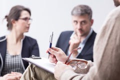 Therapist taking notes during marriage therapy session stock photo Therapist taking notes during marriage therapy session stock photo
