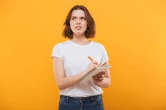 Thinking young woman writing notes. Looking aside. royalty free stock image Thinking young woman writing notes. Looking aside. royalty free stock image