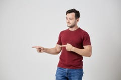 Thoughtful man in the burgundy t-shirt points his fingers to the side royalty free stock images Thoughtful man in the burgundy t-shirt points his fingers to the side royalty free stock images