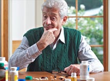 Thoughtful Senior Man Looks At His Many Pills Royalty Free Stock Photo Thoughtful Senior Man Looks At His Many Pills Royalty Free Stock Photo