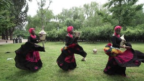 Three african women are dancing a folk dance in traditional costumes with wicker baskets