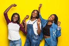 Three Beautiful African Women Dancing Isolated Over Yellow Background Stock Photo Three Beautiful African Women Dancing Isolated Over Yellow Background Stock Photo