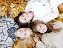 Three Girls Lying In Leaves Stock Images