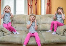 Three girls on the sofa playing harmonica stock images Three girls on the sofa playing harmonica stock images