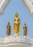 Three Graceful And Peaceful Golden Buddha Statues Standing Under Beautiful White Arch With Blue Sky Background Stock Images