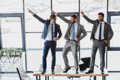 three happy young businessmen dancing on table royalty free stock photography three happy young businessmen dancing on table royalty free stock photography