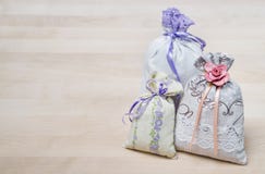 Three lavender scent pouches on wooden board or table. Scented sachets on wood with copy space. Fragrance bags for fresh home. royalty free stock image Three lavender scent pouches on wooden board or table. Scented sachets on wood with copy space. Fragrance bags for fresh home. royalty free stock image