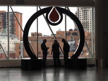 Three Men In Rogers Place Under Oilers` Logo Looking At Downtown Edmonton