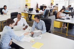 Three men working together in a busy office, elevated view stock photos Three men working together in a busy office, elevated view stock photos