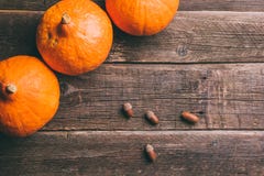 Three orange pumpkins and acorns on wooden background royalty free stock photo Three orange pumpkins and acorns on wooden background royalty free stock photo
