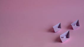 Three purple paper boats on a light pink background royalty free stock images Three purple paper boats on a light pink background royalty free stock images