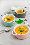 Three small serving pots or bowls with cream soup made of red lentils with rusks, spices and herbs parsley, coriander Stock Images Three small serving pots or bowls with cream soup made of red lentils with rusks, spices and herbs parsley, coriander Stock Images