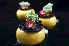 Three yellow round desserts with chocolate nest decoration, cranberries and pistachio sponge stock photos Three yellow round desserts with chocolate nest decoration, cranberries and pistachio sponge stock photos