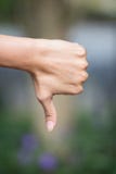Thumb down female hand sign on nature background. royalty free stock images Thumb down female hand sign on nature background. royalty free stock images