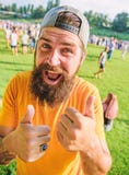 Thumbs ups to success. Happy hipster with mustache and beard extending hands with thumbs ups. Bearded man wearing stock photo Thumbs ups to success. Happy hipster with mustache and beard extending hands with thumbs ups. Bearded man wearing stock photo