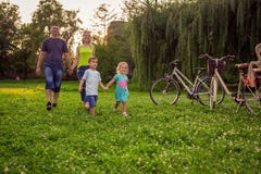 Tiempo divertido - ni?os que caminan con los padres en parque fotografía de archivo libre de regalías Tiempo divertido - ni?os que caminan con los padres en parque fotografía de archivo libre de regalías