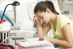 Tiener die bij Bureau in Slaapkamer bestuderen Stock Afbeelding Tiener die bij Bureau in Slaapkamer bestuderen Stock Afbeelding
