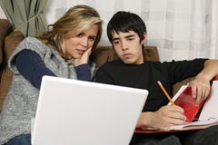Tieners die thuiswerk met laptop doen stock afbeeldingen Tieners die thuiswerk met laptop doen stock afbeeldingen