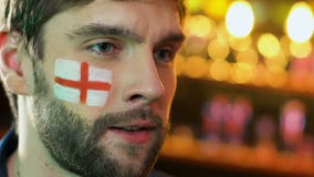 Tifoso maschio con la bandiera inglese sul ribaltamento della guancia circa perdita favorita del gruppo video d archivio Tifoso maschio con la bandiera inglese sul ribaltamento della guancia circa perdita favorita del gruppo video d archivio