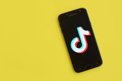 Tiktok logo on samsung smartphone screen on yellow background. TikTok is a popular video-sharing social networking service owned