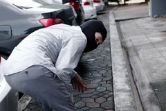 Tillbaka sikt av den maskerade tjuven i den svarta balaclavaen som försöker att bryta in i bilen Brottsligt brotts- begrepp fotografering för bildbyråer Tillbaka sikt av den maskerade tjuven i den svarta balaclavaen som försöker att bryta in i bilen Brottsligt brotts- begrepp fotografering för bildbyråer