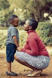Tilt Shift Lens Photography of Woman Wearing Red Sweater and White Skirt While Holding a Boy Wearing White and Black Crew-neck Shi Stock Photos Tilt Shift Lens Photography of Woman Wearing Red Sweater and White Skirt While Holding a Boy Wearing White and Black Crew-neck Shi Stock Photos