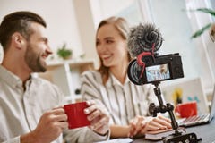 Time för ett avbrott Unga positiva bloggers dricker te, innan de startar online-tryckning arkivfoto Time för ett avbrott Unga positiva bloggers dricker te, innan de startar online-tryckning arkivfoto