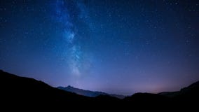 Timelapse night sky stars with milky way on mountain background