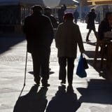 TIMISOARA RUMÄNIEN -12 13 2016 gamla par går handen - i - handen på en gata i det gamla centret in i fullt solljus arkivbild TIMISOARA RUMÄNIEN -12 13 2016 gamla par går handen - i - handen på en gata i det gamla centret in i fullt solljus arkivbild