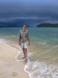 Tipo bello su una spiaggia esotica passeggiata sulla spiaggia prima di pioggia tropicale fotografie stock libere da diritti Tipo bello su una spiaggia esotica passeggiata sulla spiaggia prima di pioggia tropicale fotografie stock libere da diritti