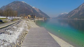 Tir aérien de quai en bois de lac, surface profonde de l'eau bleue, belles montagnes banque de vidéos Tir aérien de quai en bois de lac, surface profonde de l'eau bleue, belles montagnes banque de vidéos