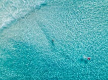 Tir aérien des nageurs sur une belle plage avec l'eau bleue et le sable blanc - eau profonde photo stock Tir aérien des nageurs sur une belle plage avec l'eau bleue et le sable blanc - eau profonde photo stock